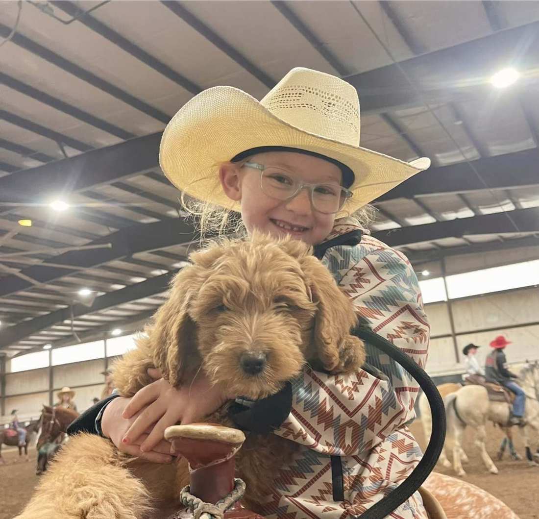 One of the girls on horseback holding a puppy